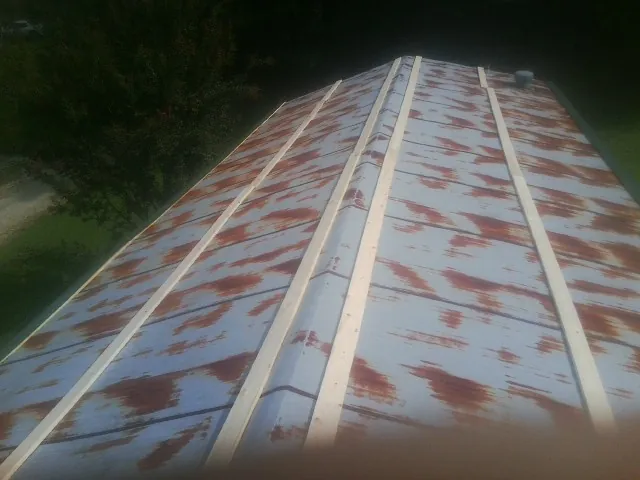 Rusted metal roof panels with new wood purlins before replacement — Storm Damage Roof Repair in Mifflinburg by Roofing Brothers