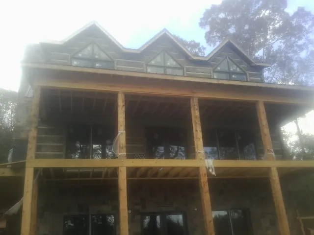 Dormers and porch framing on a large log home under construction — Roof Coating work by our crew in Mifflinburg