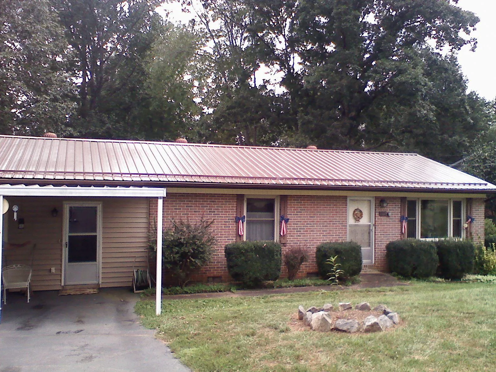 Bronze metal roof and carport on a brick ranch home — Roof Repair work by our crew in Mifflinburg